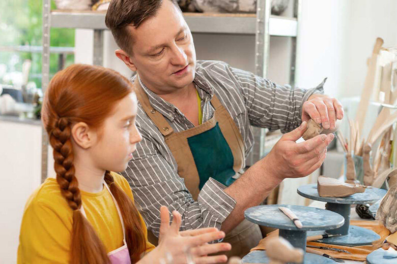 Ein Erwachsener und ein Kind arbeiten gemeinsam in einem Atelier.
