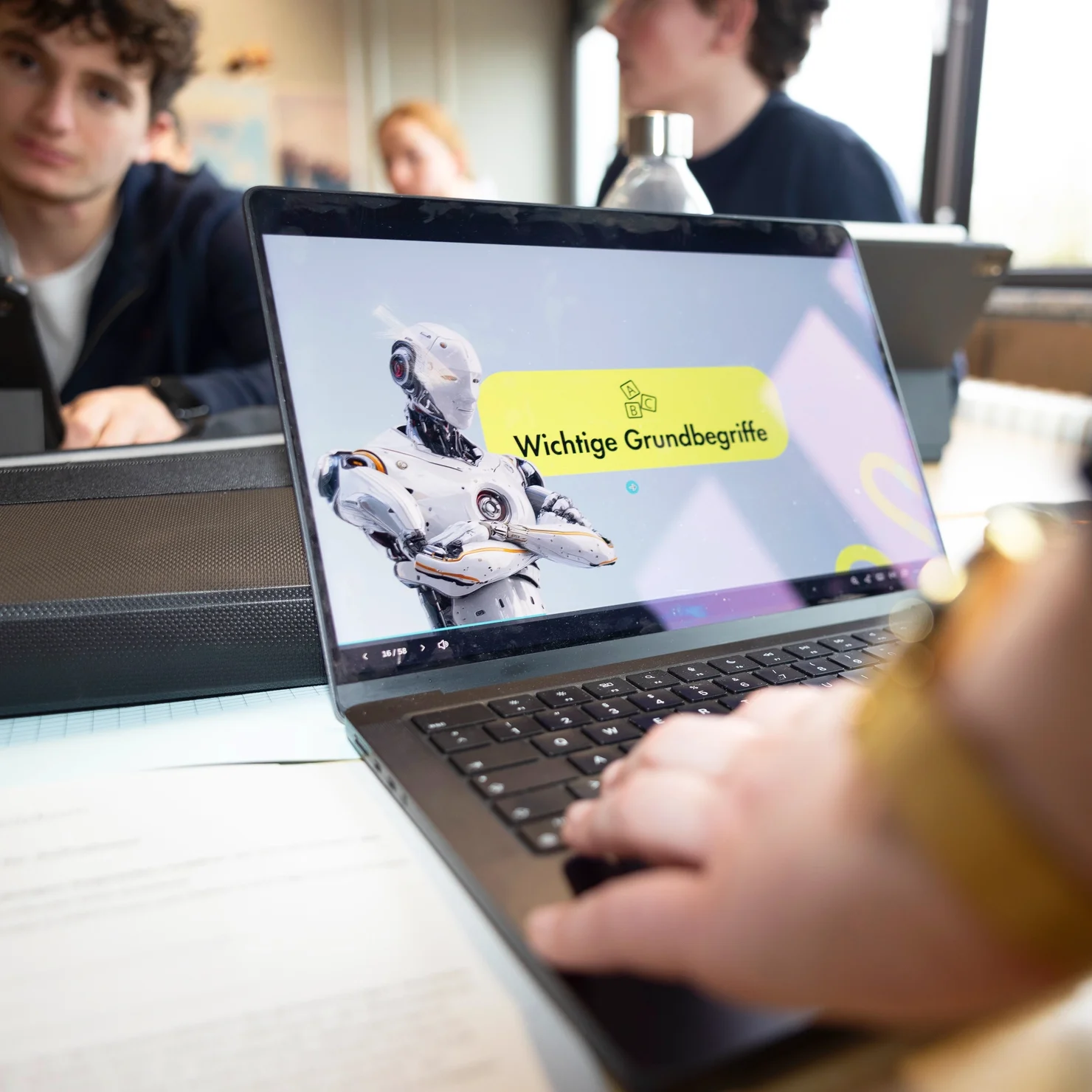 Ein Lehrkraft arbeitet im Klassenraum am Laptop und nutzt eine KI-Anwendung.