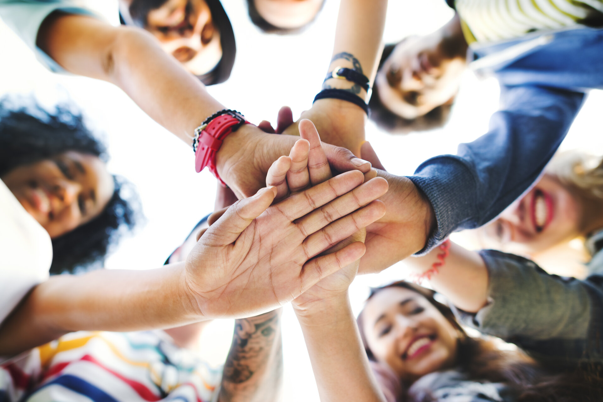 Menschen legen die Hände aufeinander.