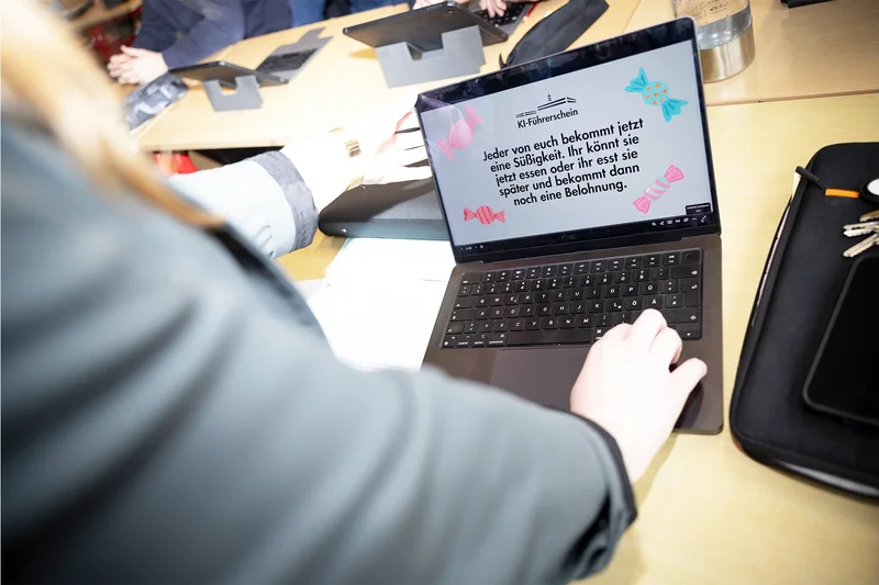 Eine Lehrkraft nutzt auf einem Laptop eine Anwendung zum KI-Führerschein.