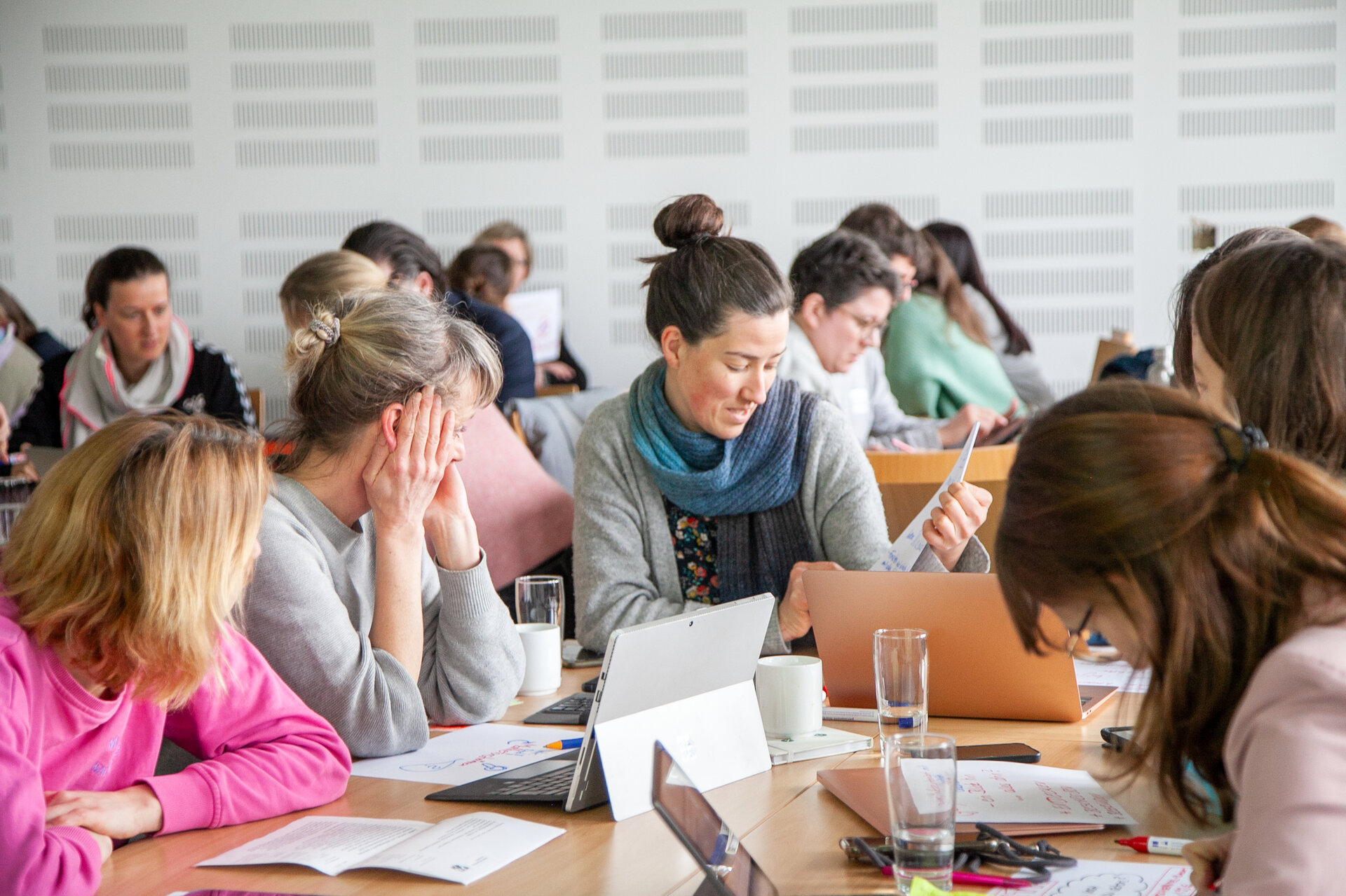 Erwachsene sitzen gemeinsam an einem großen Arbeitstisch.