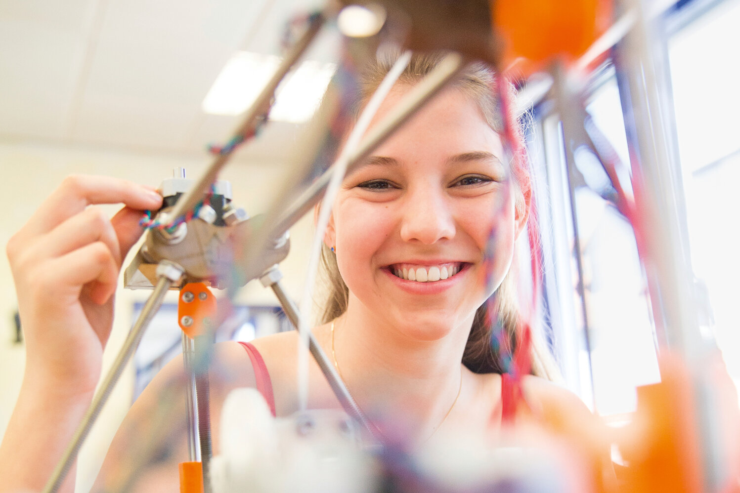 Ein Mädchen arbeitet an einem Roboterarm.