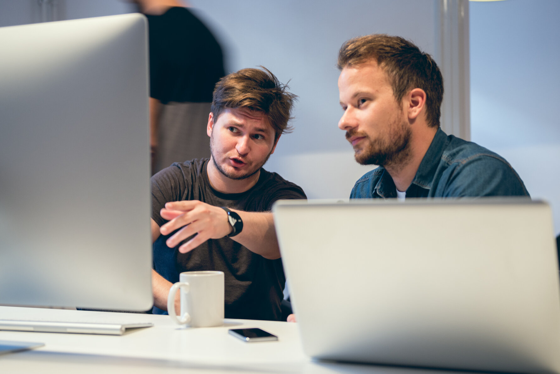 Zwei Erwachsene sitzen hinter einem Computer.