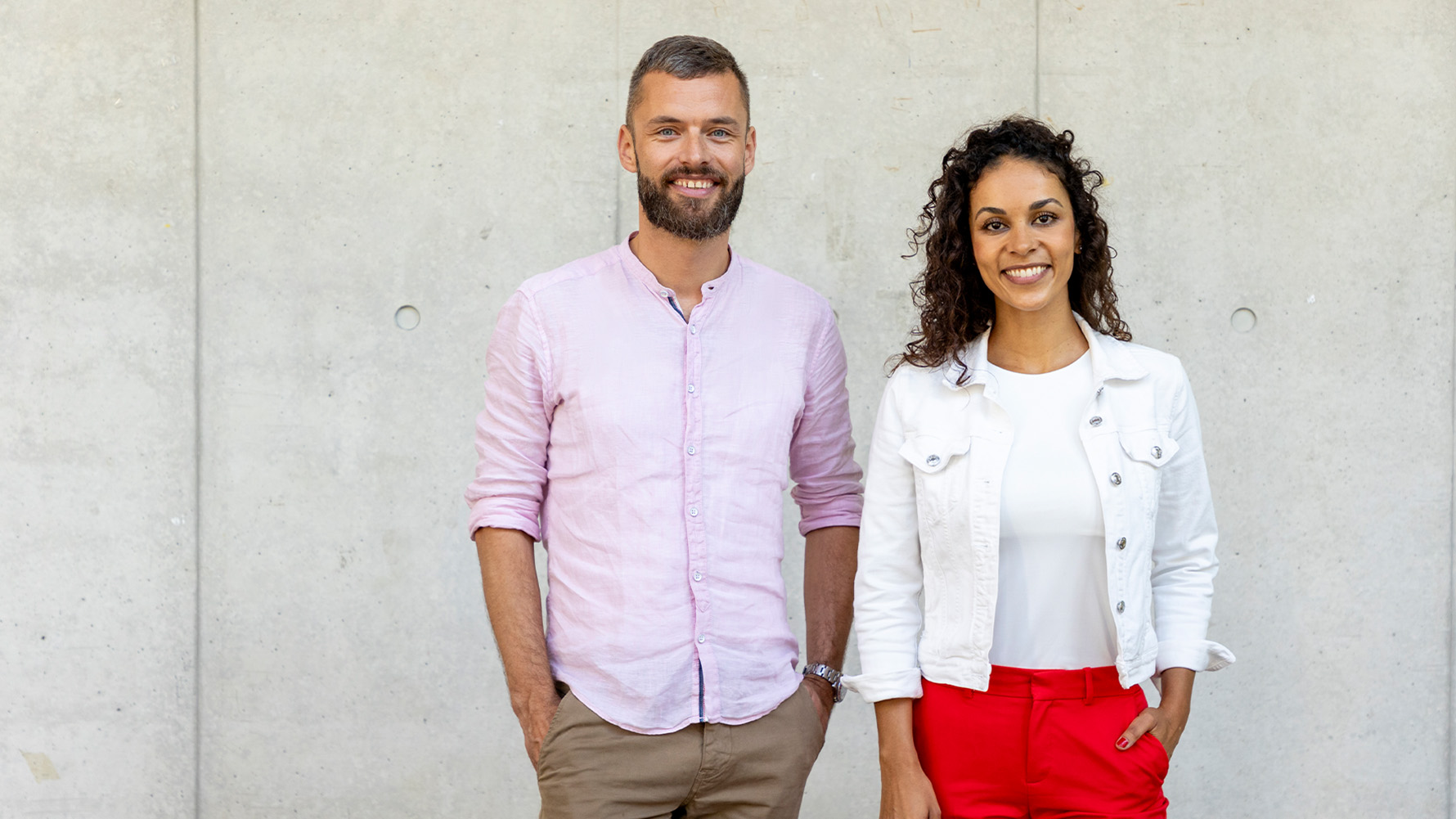 Dr. med. Florence Randrianarisoa und Jacob Chammon stehen vor einer Betonwand.