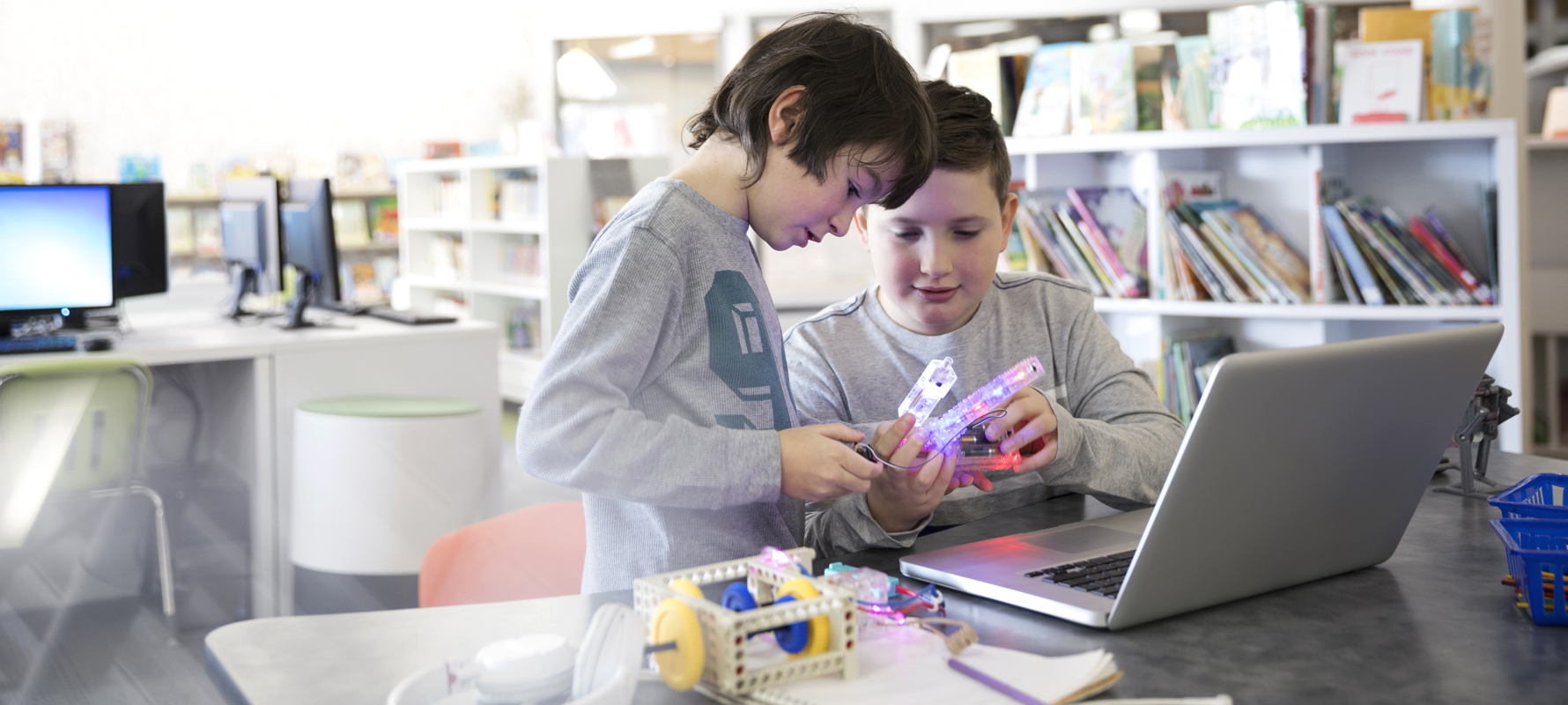Zwei Jungs programmieren in der Bibliothek