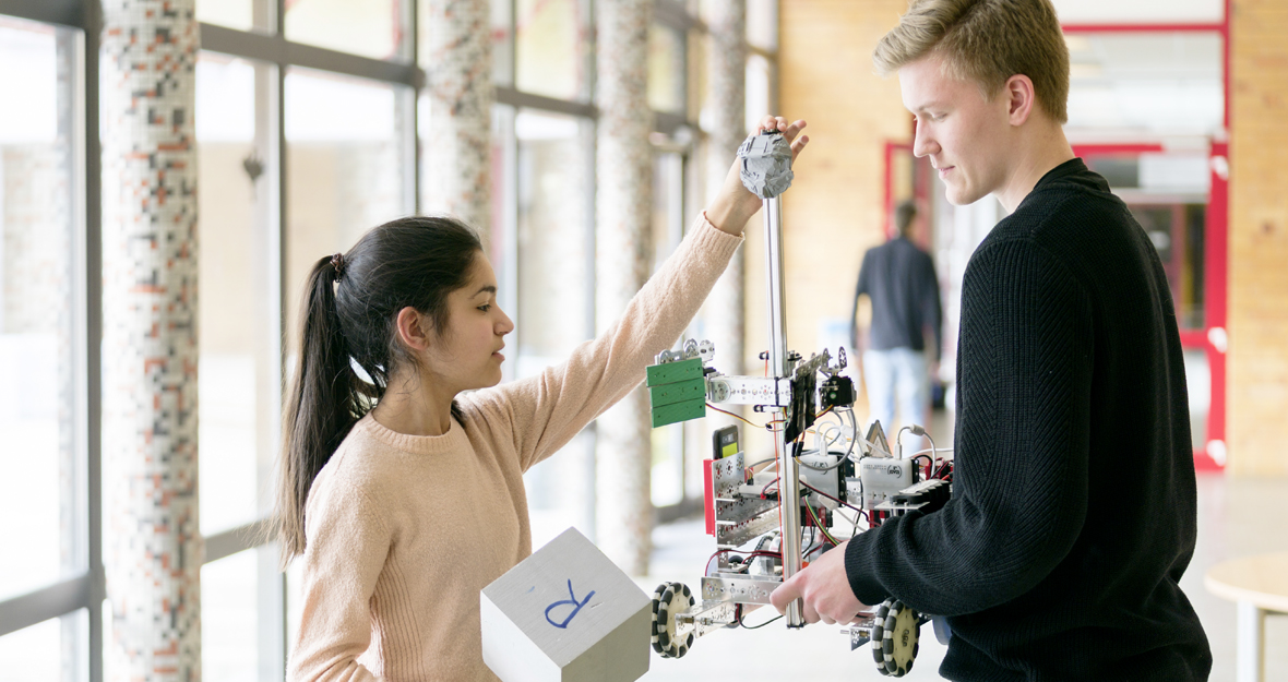 Mädchen und Junge halten einen selbstgebauten Roboter