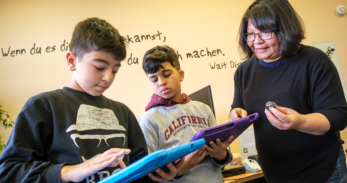 Zwei Schüler mit Tablet und Lehrerin