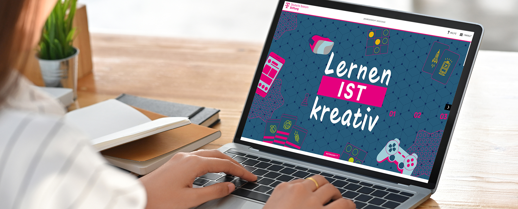 Frau sitzt vor Laptop und schaut sich den Jahresbericht der Deutsche Telekom Stiftung an.