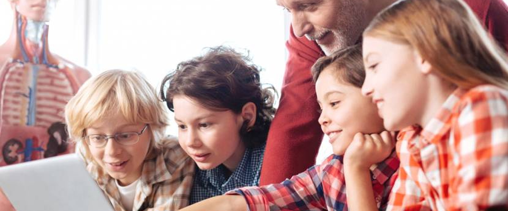 Lehrer erklärt seinen Schüler etwas und zeigt auf den Laptop