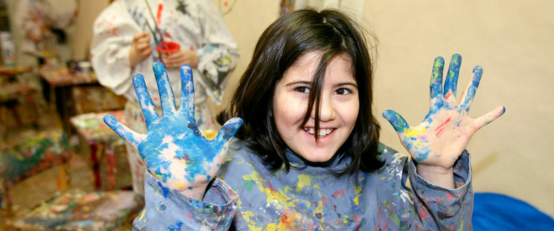 Kind mit bunten Händen voll Fingerfarbe