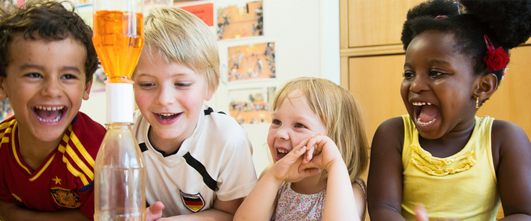 Vier kleine Kinder erforschen ein Experiment