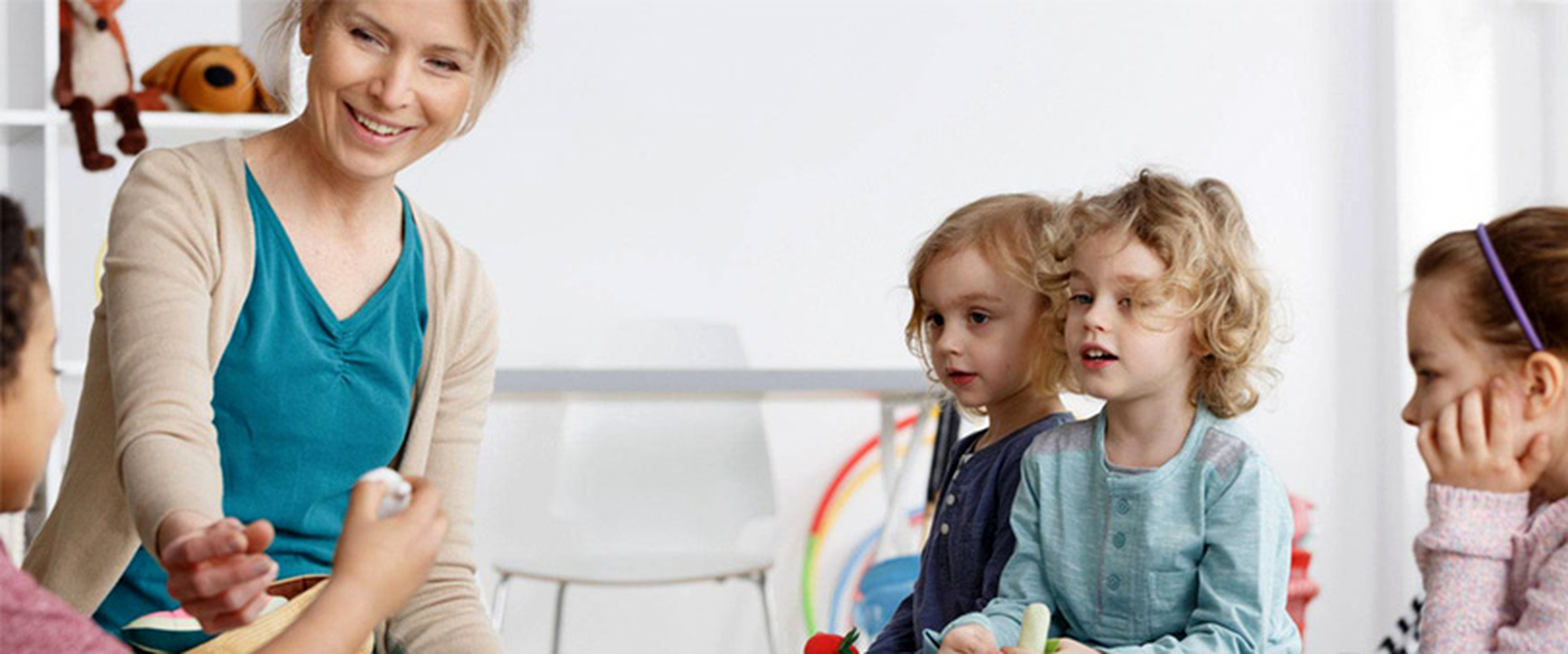 Erzieherin liest Kinder etwas vor