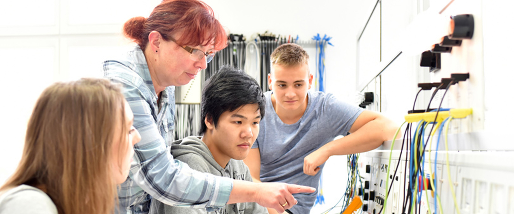 Lehrerin erklärt Schülern einen technischen Vorgang