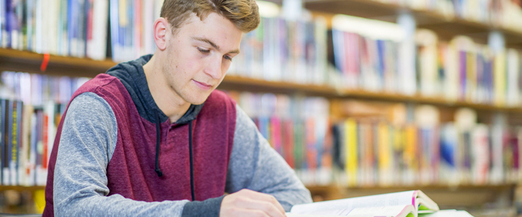 Ein Schülerstudierender lernt in der Bibliothek