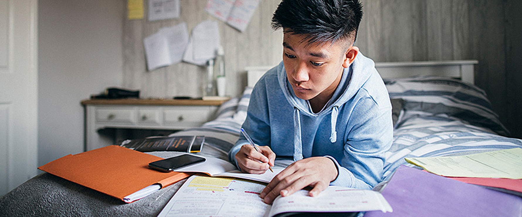 Schüler lernt und schaut dabei auf seine Bücher