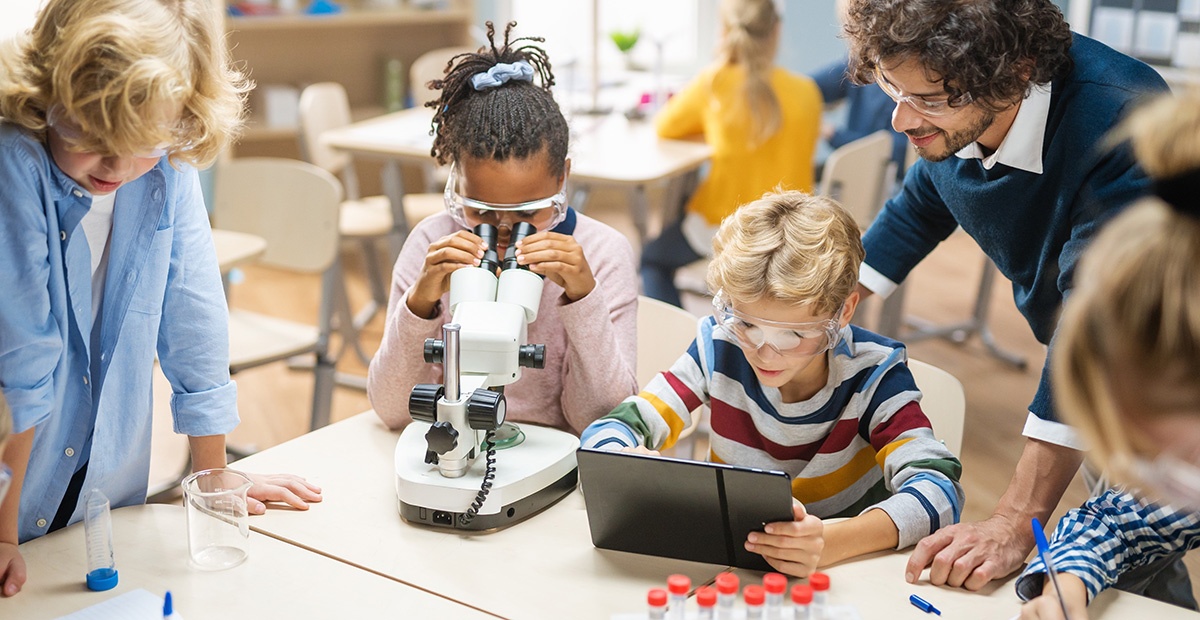 Lehrkraft unterstützt Schüler:innen im Unterricht