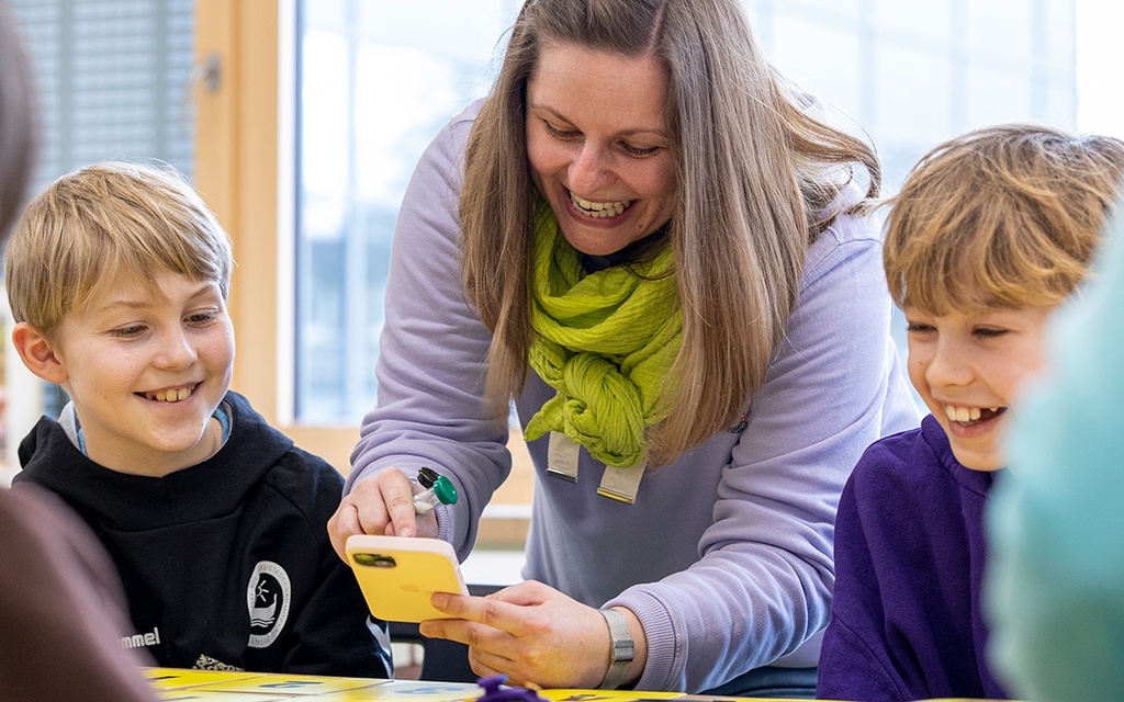 Schülerinnen und Schüler spielen gemeinsam mit Lehrkraft Moonshot.