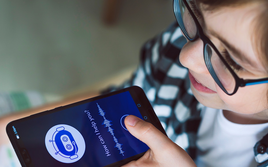 Junge hat ein Smartphone mit einer KI-Anwendung in der Hand.