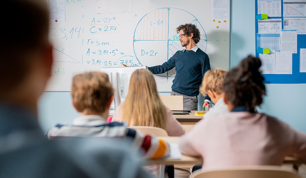 MINT-Lehrkraft steht vor Schulklasse