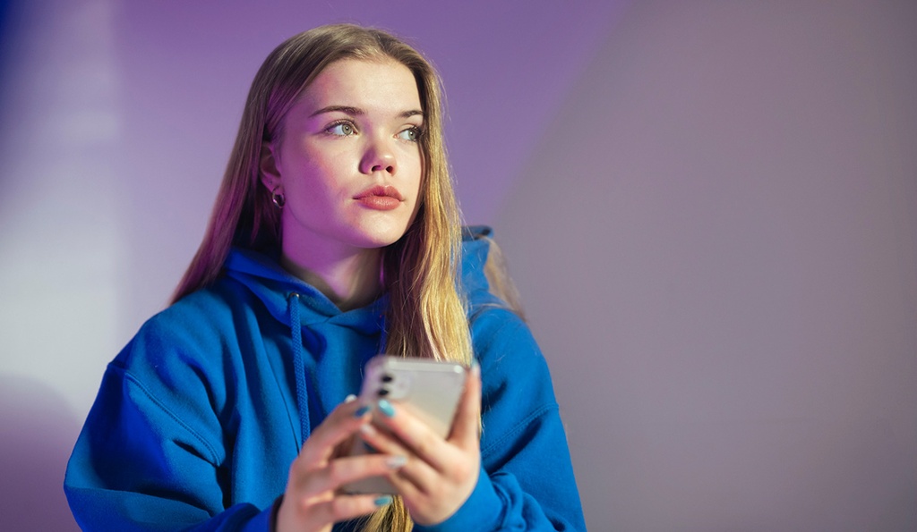 Jugendliches Mädchen mit Smartphone in der Hand.