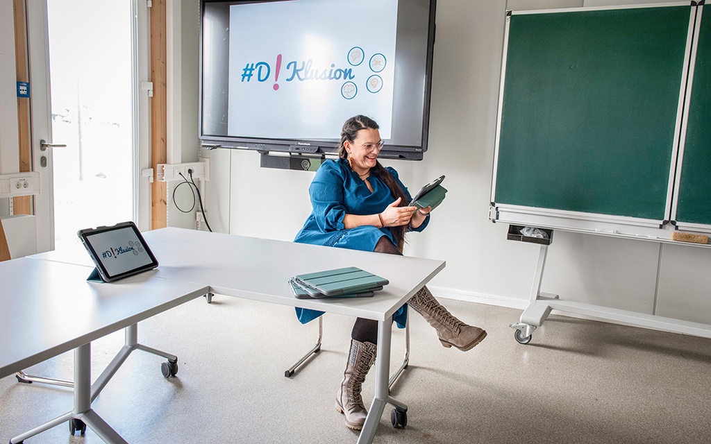 Lea Schulz sitzt mit einem Tablet im Klassenzimmer.
