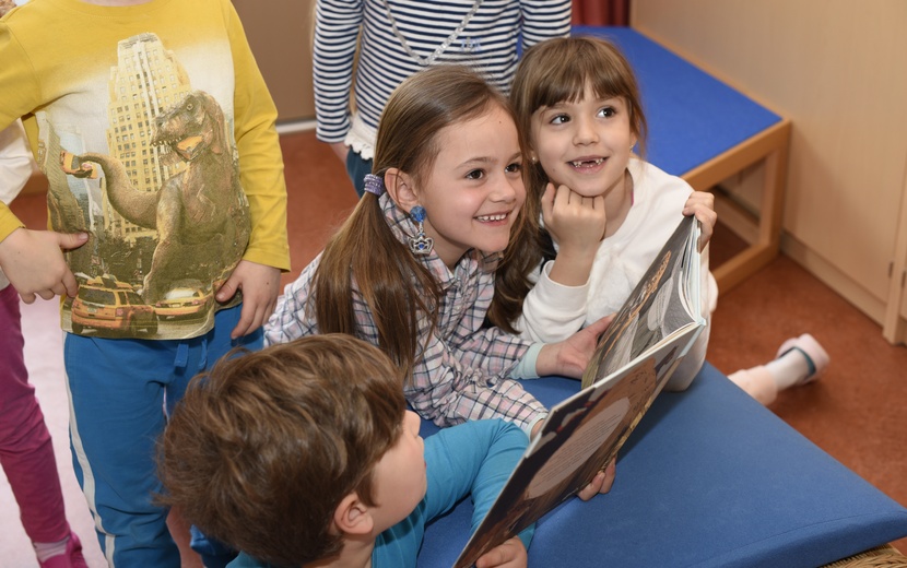 Nach der Vorleseaktion schauen die Kinder sich das Buch gemeinsam an.