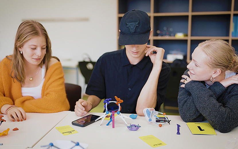 Drei Jugendliche spielen das Spiel Moonshot.