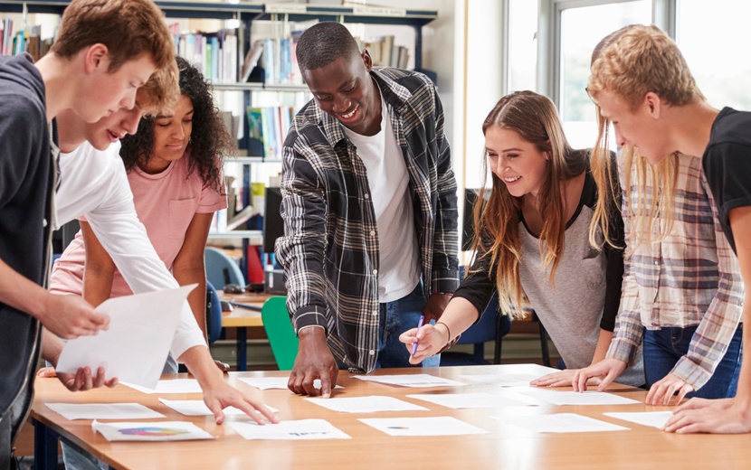 Lehrkraft und Schüler arbeiten an Computern und Laptops.