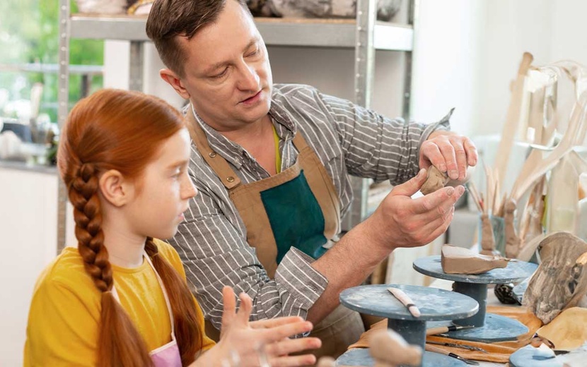 Schülerin und Lehrkraft arbeiten gemeinsam in einer Tonwerkstatt.