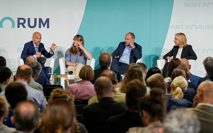 Menschen sitzen vor einer Bühne beim Nationalen MINT Forum.