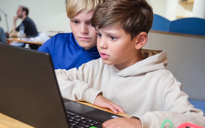 Zwei Schüler sitzen vor einem Laptop.