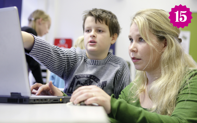 Lehrerin hilft Schüler am Computer