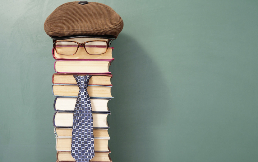 Bücherstapel mit Mütze, Brille und Krawatte
