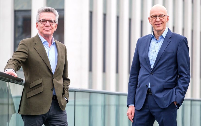Thomas de Maizière (links) und Dr. Ekkehard Winter stehen nebeneinander auf einer Fußgängerbrücke