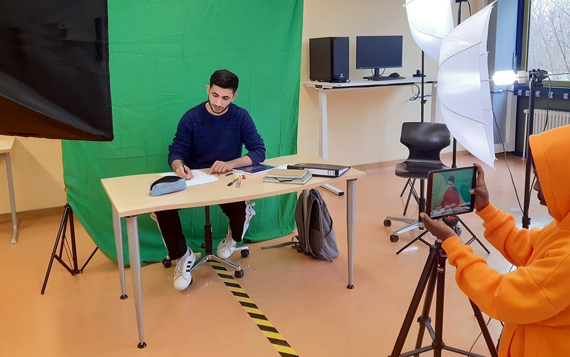 Jugendliche nehmen ein Video vor einem Greenscreen auf.