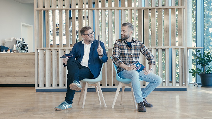 Prof. Dr. Kai Maaz und Jacob Chammon sitzen Rücken an Rücken auf zwei Stühlen und sind einander zugewandt.